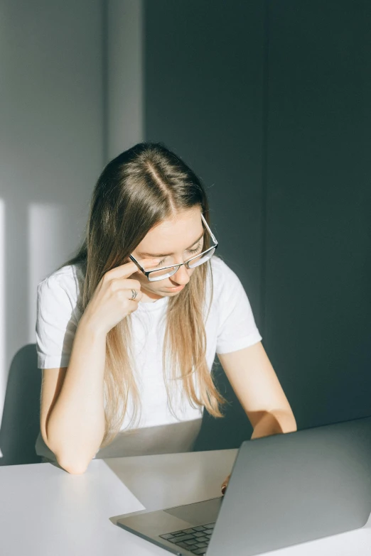 a girl sitting at a table with a laptop