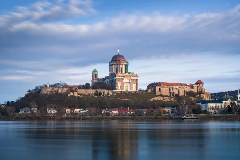 a large church sits atop a hill above the ocean