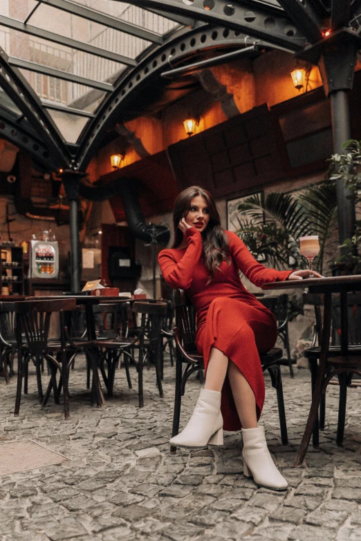 a beautiful woman sitting at a table in a restaurant