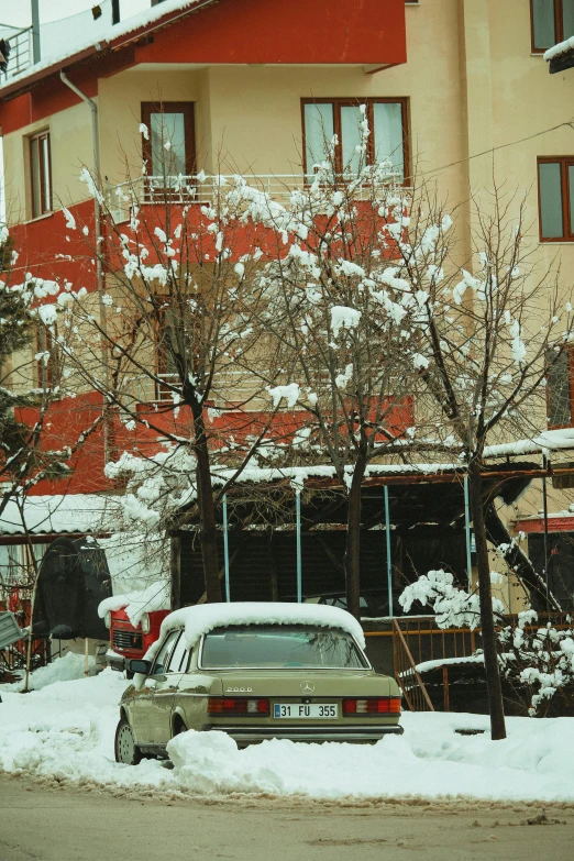 a car covered in snow is parked on the side of the street