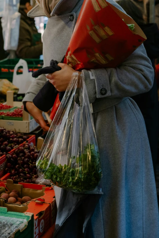 a woman standing in a market holding a bag