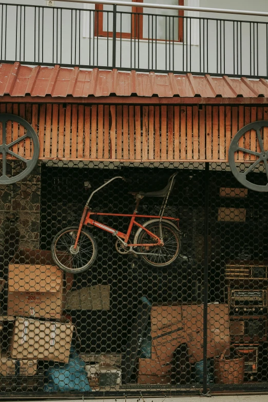 a bicycle mounted to a building near boxes and crates