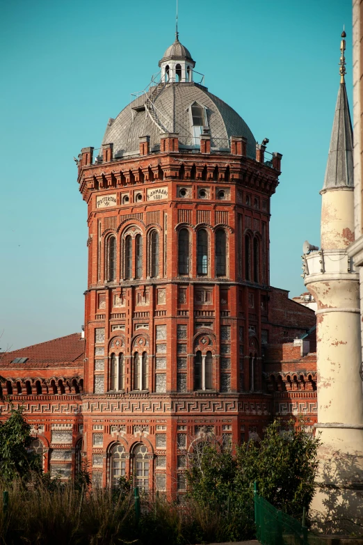 a tall brick building sitting next to a tree