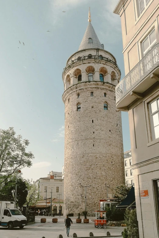 a man walking in front of an old brick tower