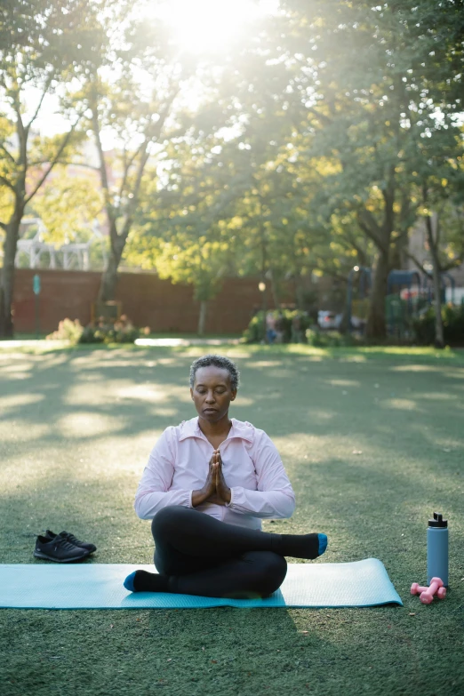 a woman doing yoga outside in a sunny area