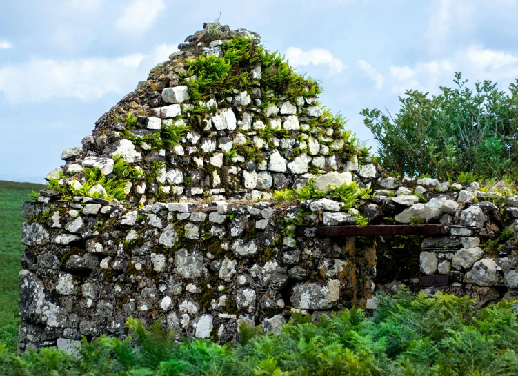 a large building made from rocks and some bushes