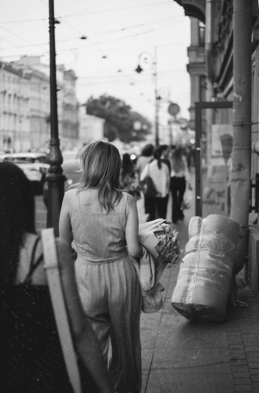 a woman walking down the sidewalk while carrying soing