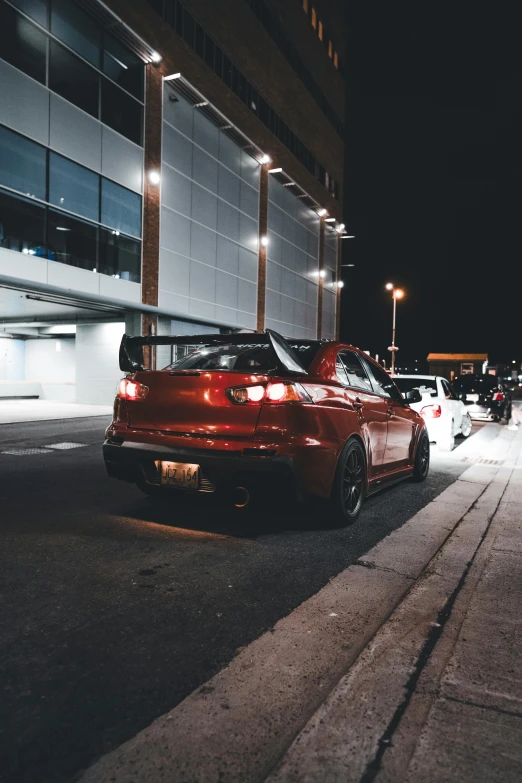two red bmw cars on a street at night