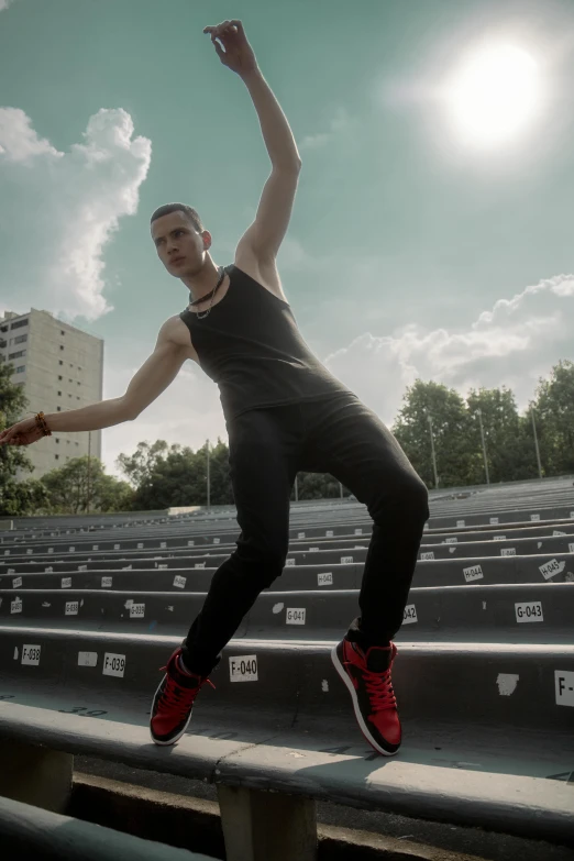 a person with their arms up standing on the edge of bleachers