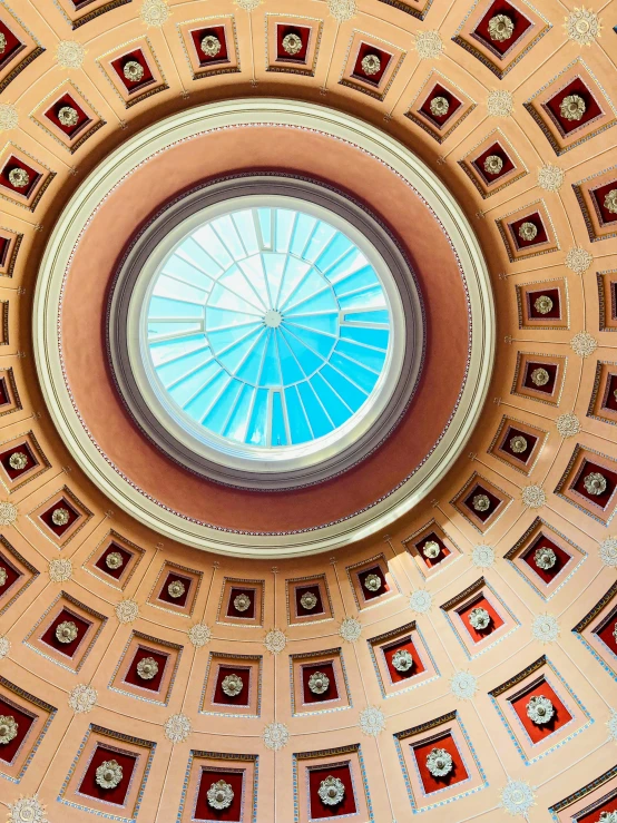 an ornate round ceiling with a blue skylight