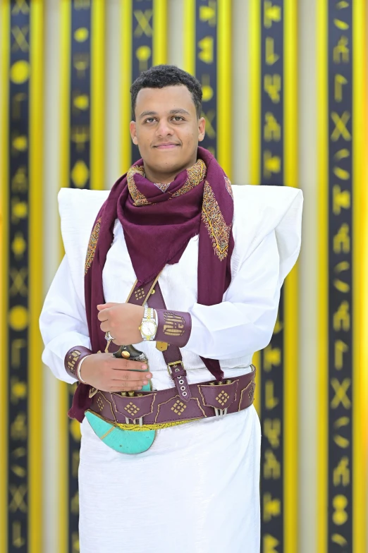 a man wearing white is standing next to a wall