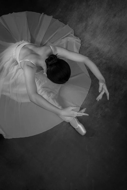 a ballet dancer on the floor with her arms outstretched