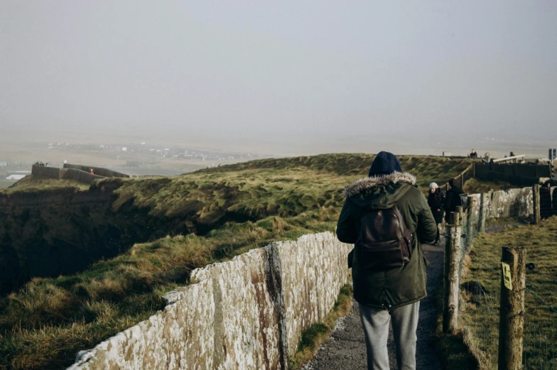 a man walking up a road in the hills