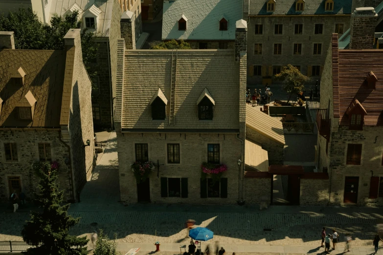 aerial view of stone buildings, people and trees