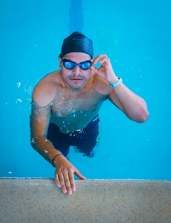 the man is wearing goggles and swimming in a pool