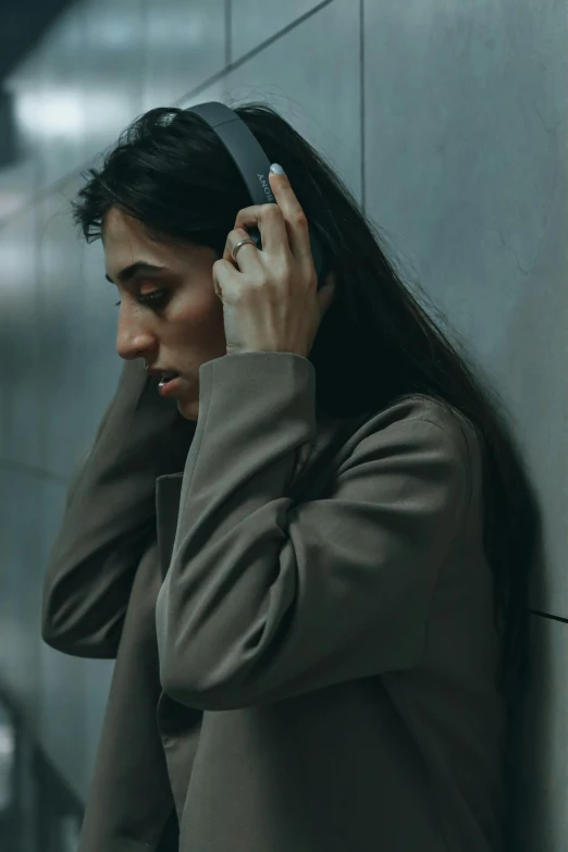 a woman wearing headbands leans against the wall