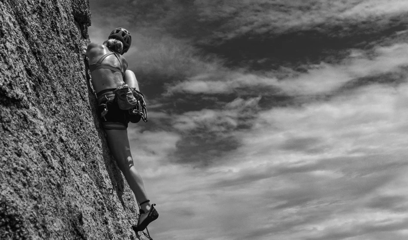 a woman on a cliff face is looking up into the sky