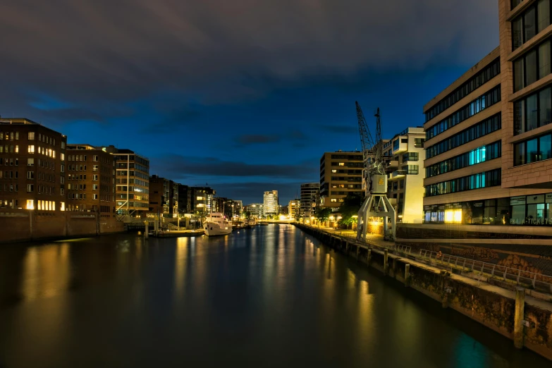 a street is lit up along the side of a river