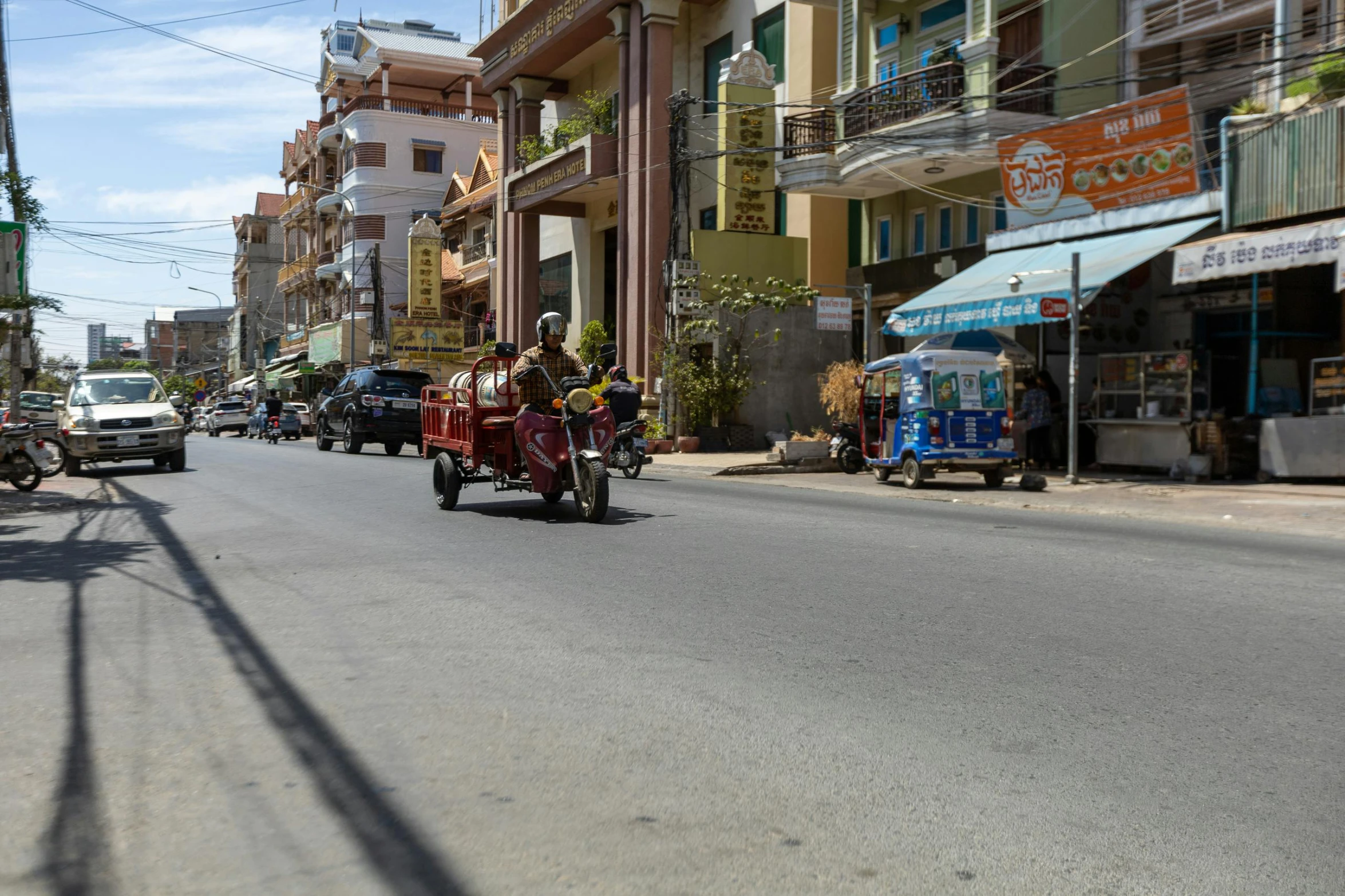 a motorcycle with a side car attached to it is driving down the street in front of other cars