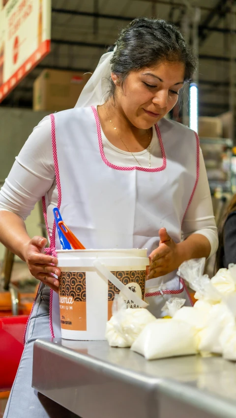 a woman wearing a white wedding dress preparing food