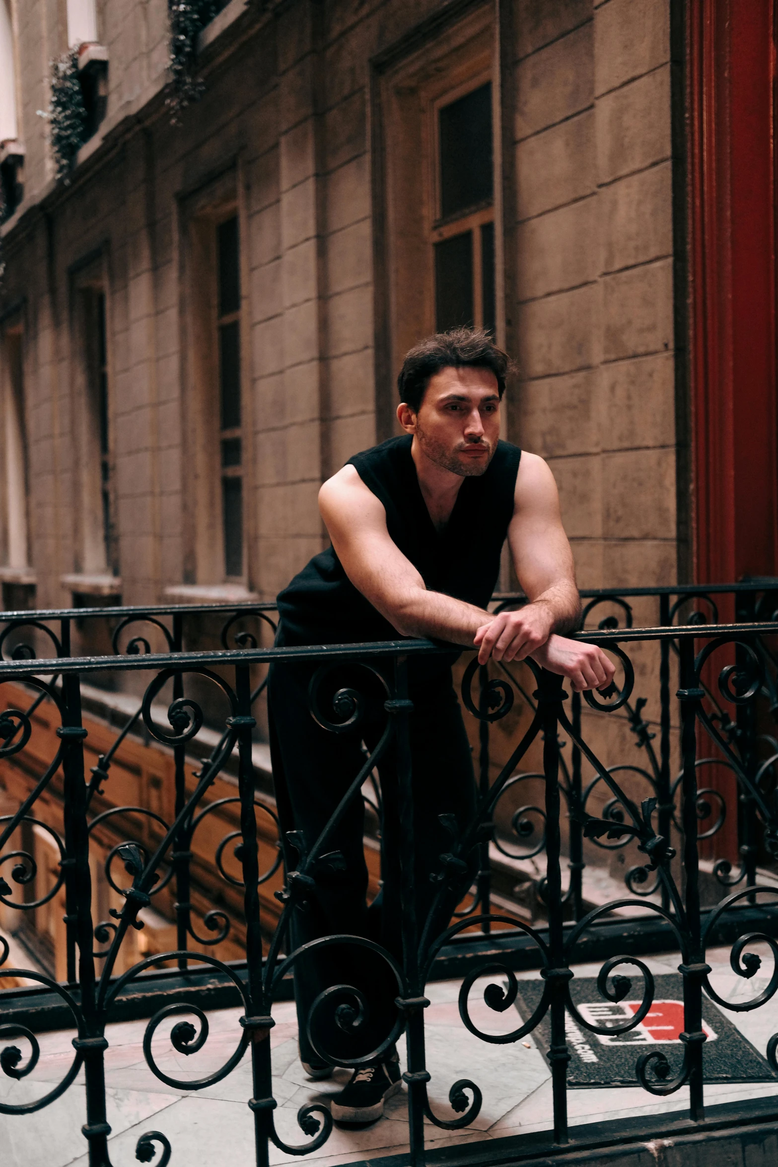 a man sitting on the balcony of a building