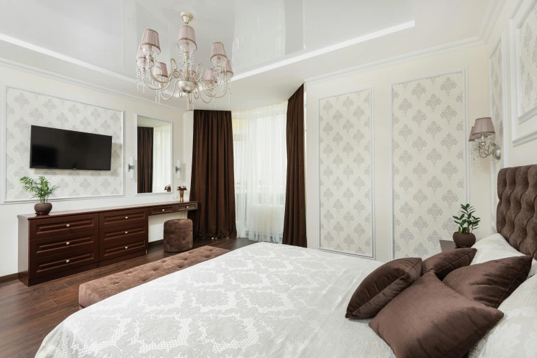 a bedroom with a chandelier, dresser and bed