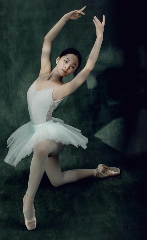 the ballerina performs a ballet pose in an artistic po