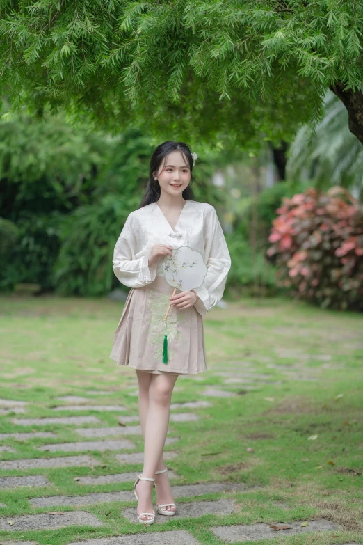 a woman with white dress and green umbrella standing under a tree