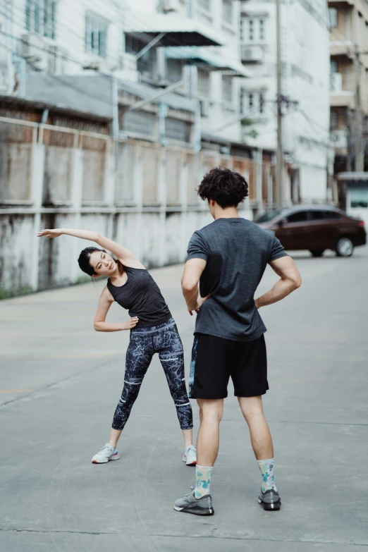 the  and girl stand facing opposite directions on the sidewalk