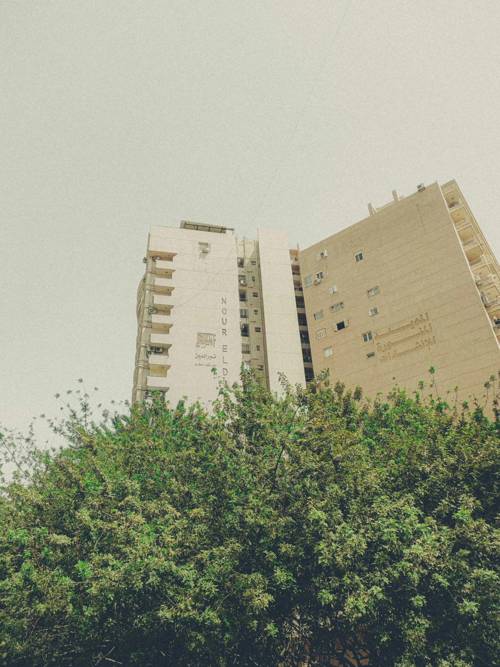 an apartment building is next to green trees and a stop sign