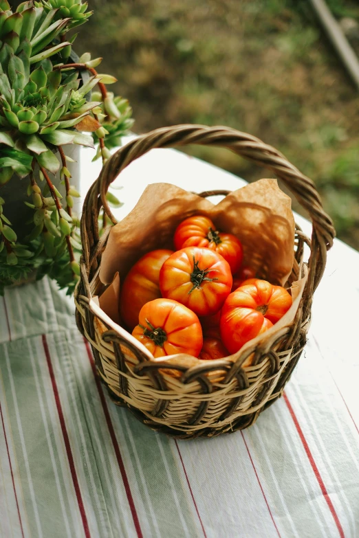 a basket of orange tomatoes on a table