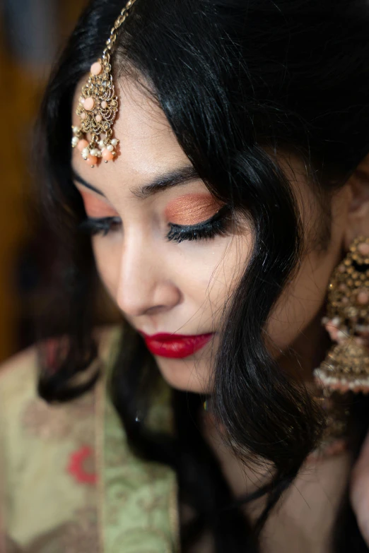 a woman with a red lipstick, head piece and makeup