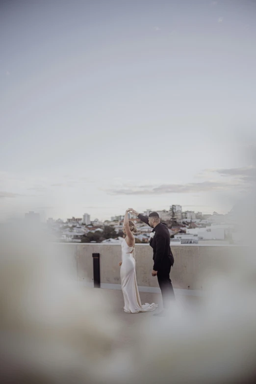 a bride and groom on top of a building