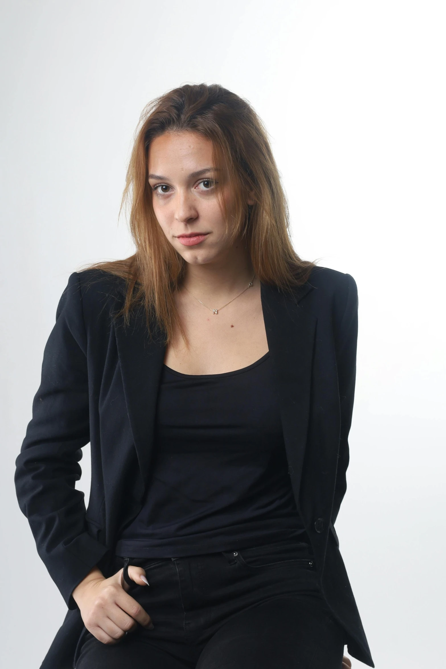woman in black suit sitting on stool, portrait