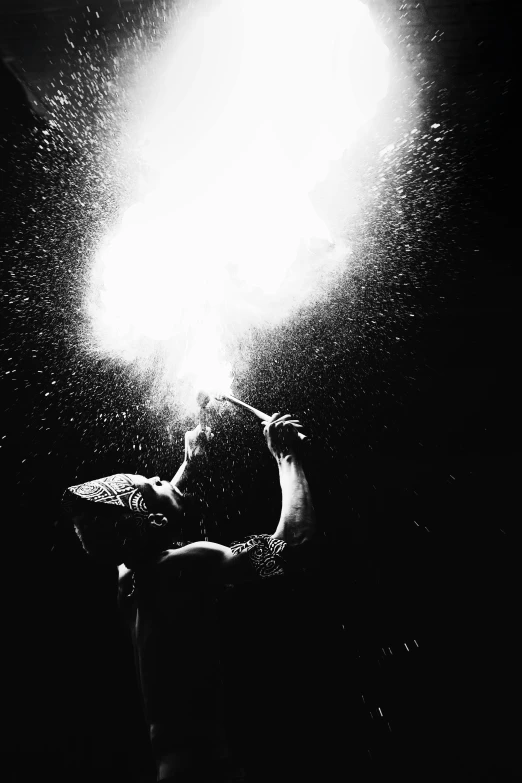 a person swimming in the dark water with a bright object above them