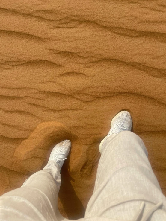 a person with their feet up in the sand