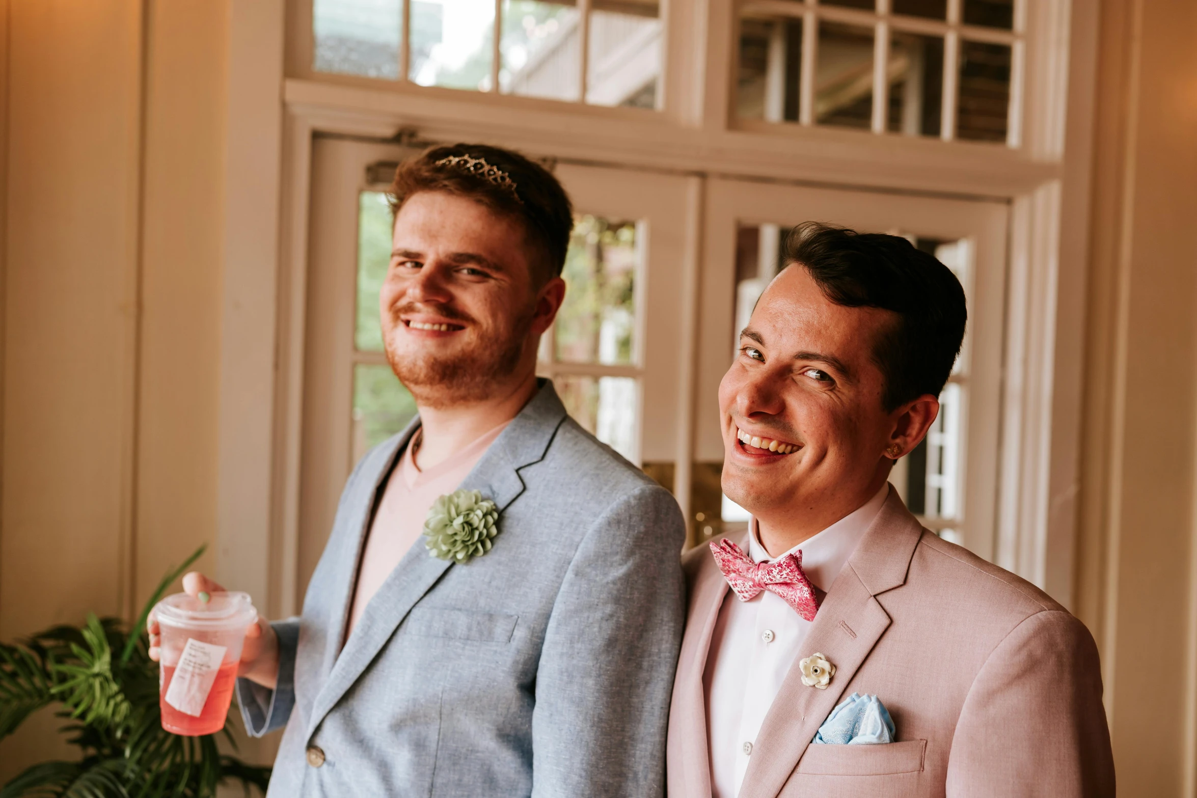 two men in pink and blue suits posing for a picture