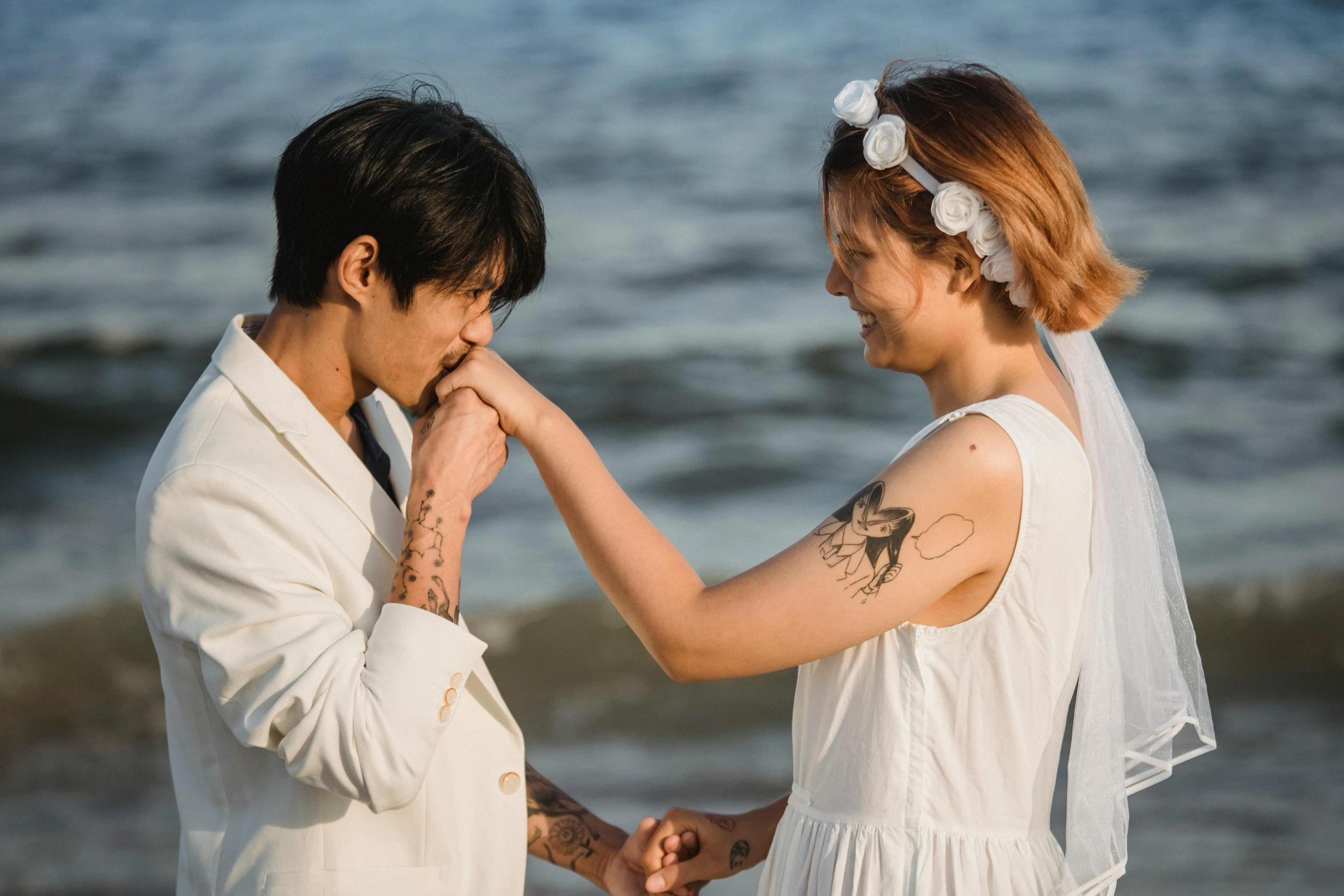 a couple of people standing next to each other on a beach