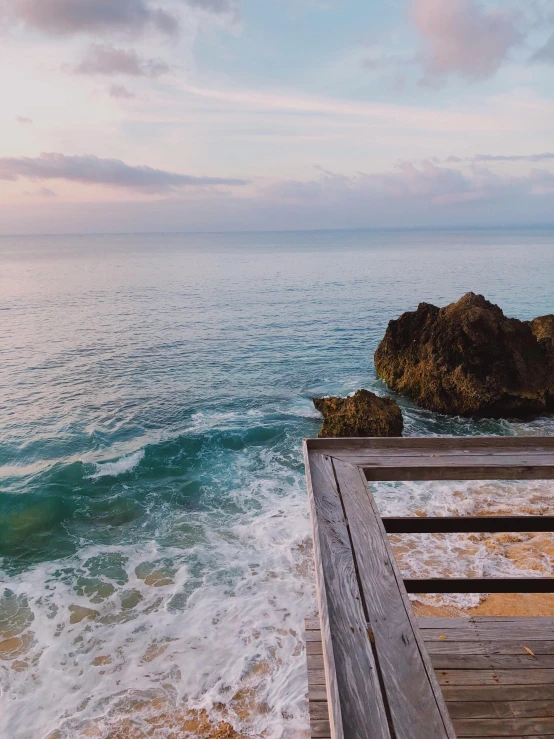 two empty benches sit on a rocky cliff