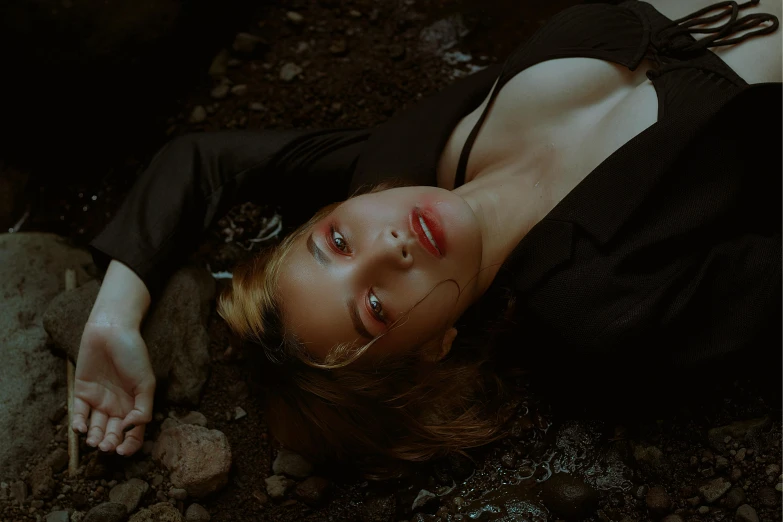 a woman lying on the ground with her hand over her face