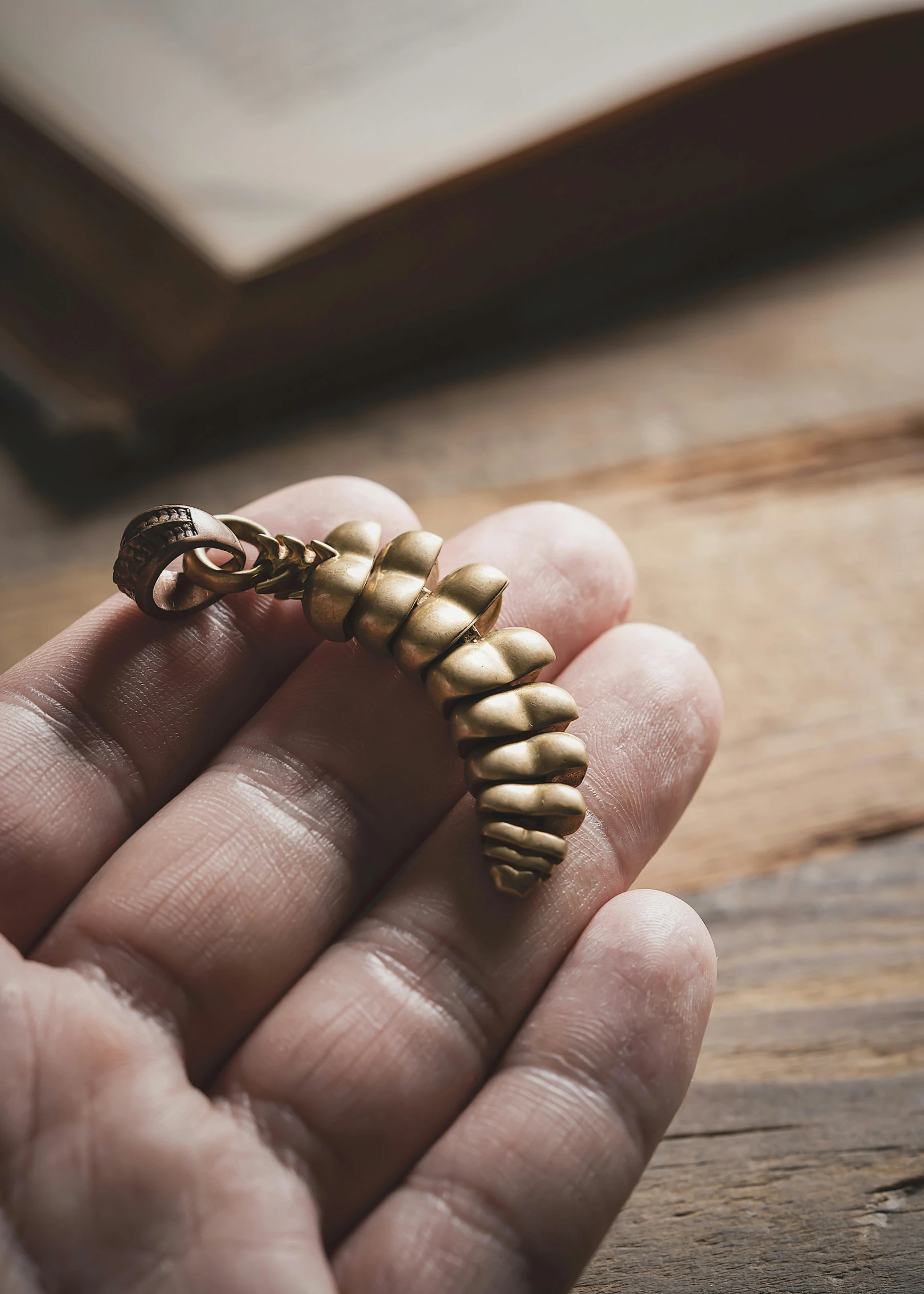 a hand holding a golden sea horse ring