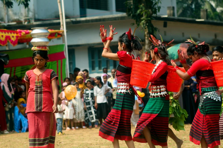 four girls dance together in front of a large crowd