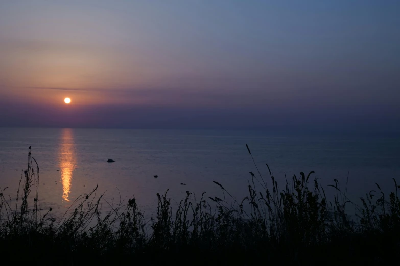 the sun setting on a large body of water