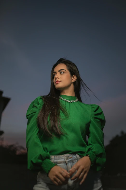 a woman standing with her hair in ponytails and wearing green