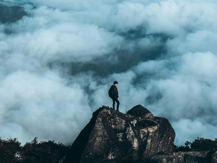 the man is standing on the top of a mountain