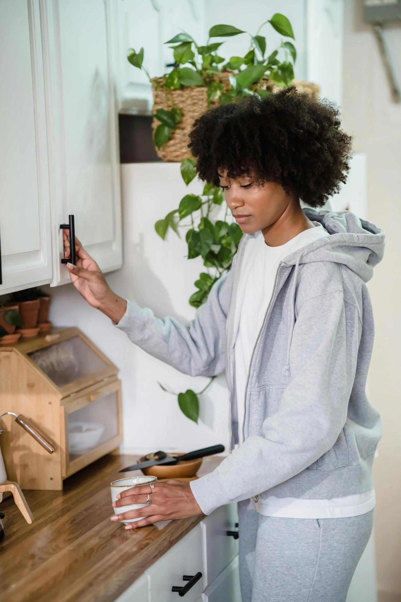 a woman in the kitchen using a clip board to put magnets on cabinets