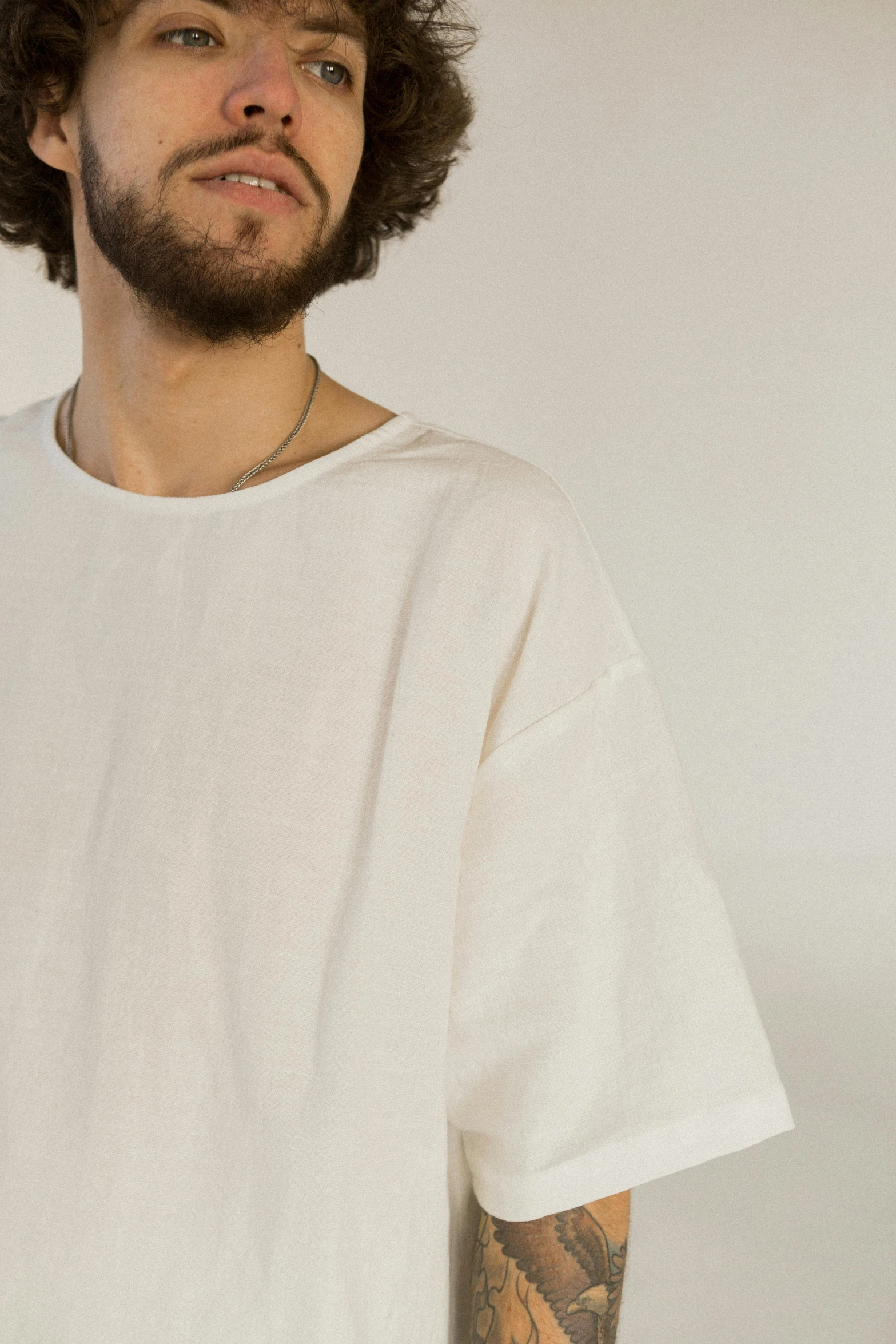 a man with long hair in white t - shirt