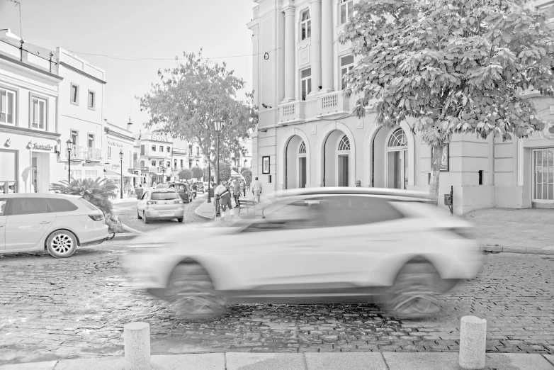 black and white pograph of a blurred car on the street