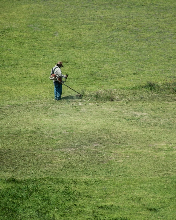 a person standing in a field holding a stick