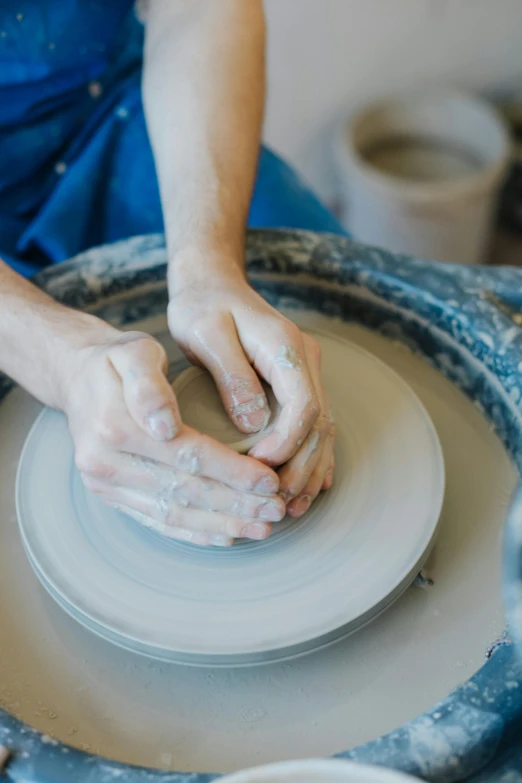 a close up of someone making a pottery vase